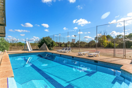 Piscina fantástica con hamacas al lado de la pista de tenis