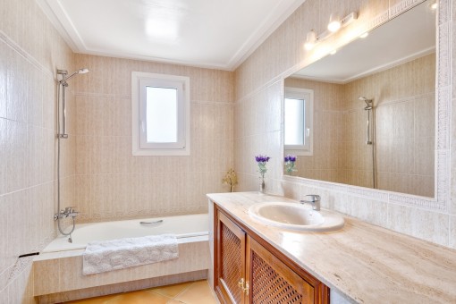 Baño en suite con bañera y luz natural