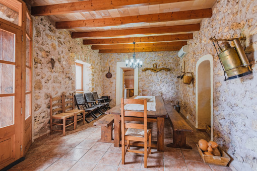 Comedor con pared de piedra y vigas de madera